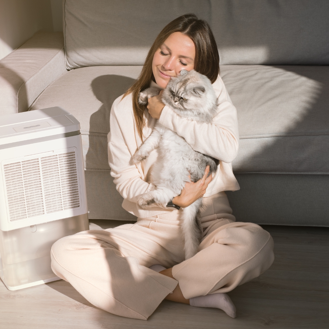 Woman cuddling her cat indoors