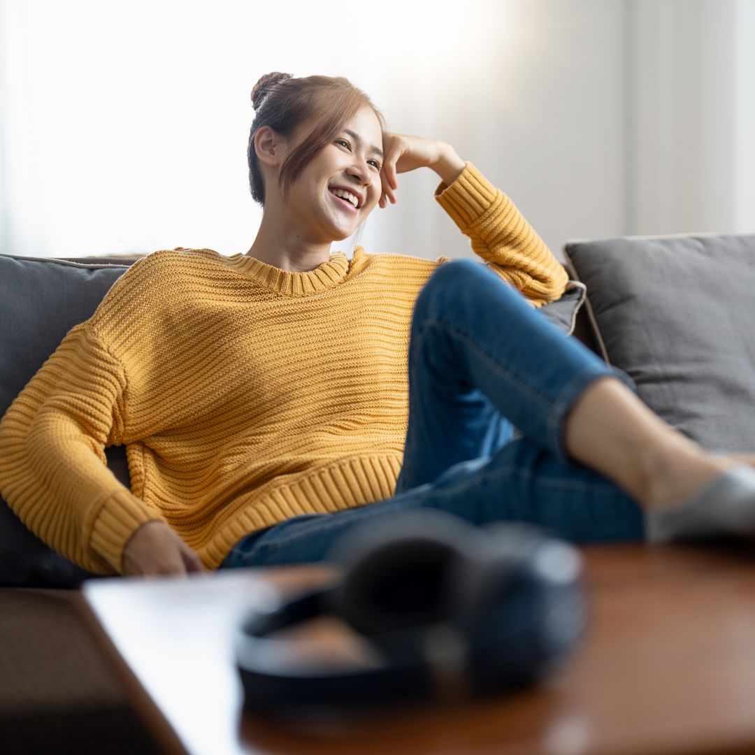 woman laughing on her couch